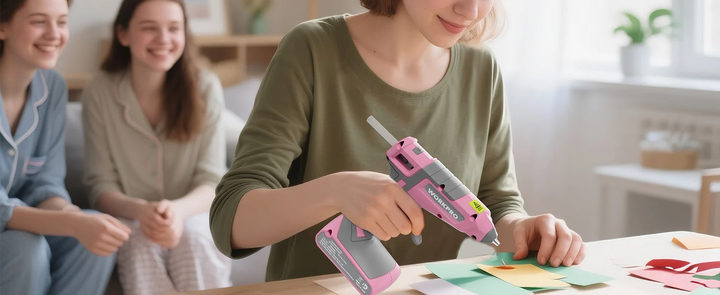 Woman using a pink cordless drill on craft paper with friends in a bright room, showing innovation and quality