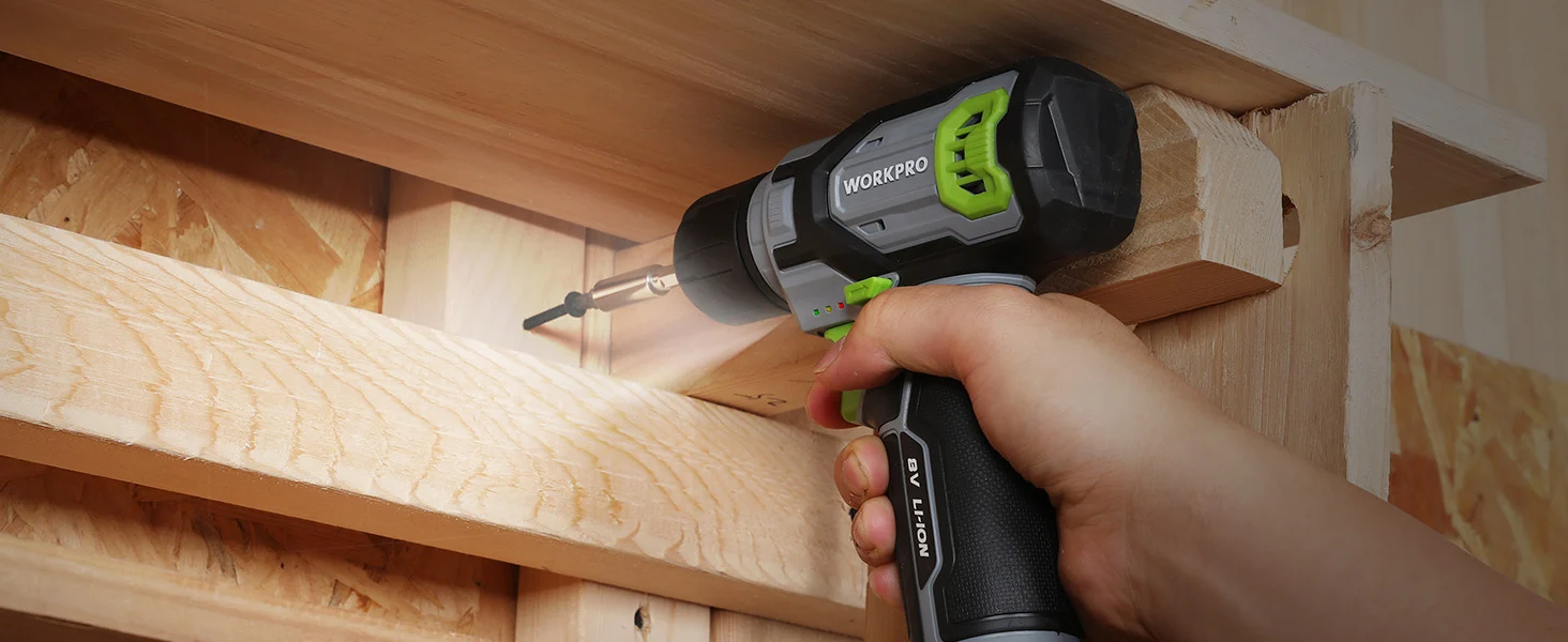 Hand using a cordless drill to screw wood beams in a workshop, with visible innovation and quality details