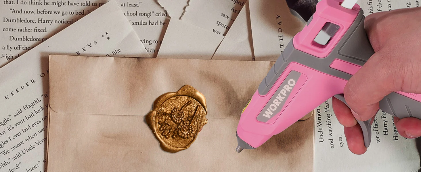 Hand holds a pink and gray WorkPro tool near a gold wax seal on an open book page