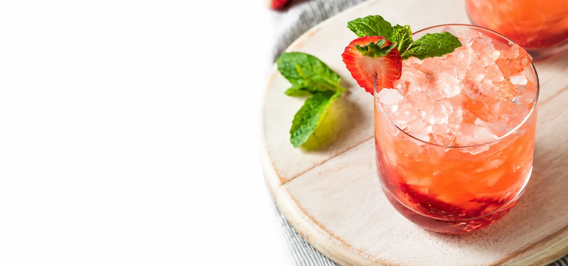 Strawberry juice topped with nugget ice and garnished with strawberry and mint