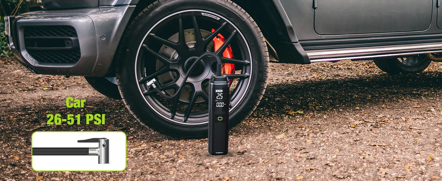 Car tire pressure gauge showing 26-51 PSI beside a black wheel on gravel, with a digital display