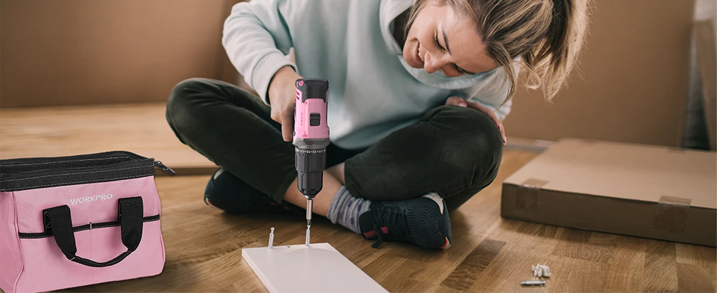 Woman assembling a flat pack with a pink and black drill, showing innovation and quality in home repairs