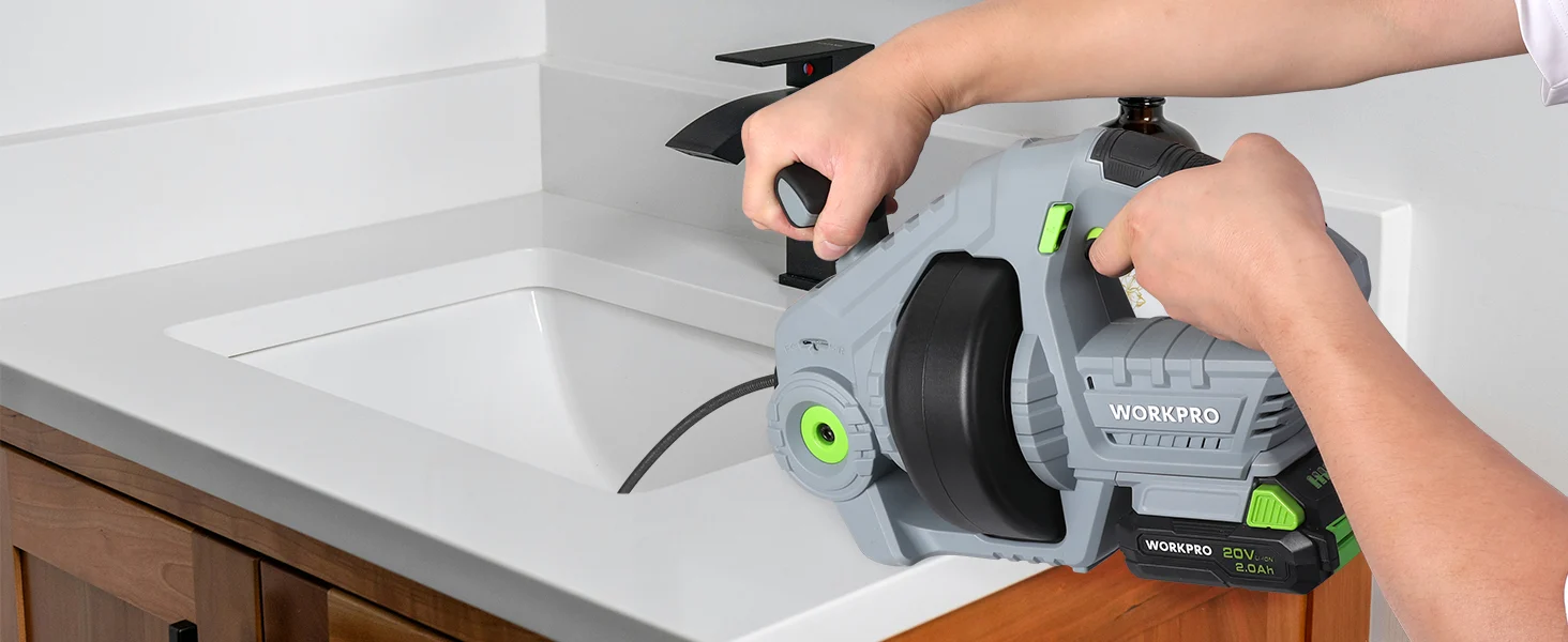 Hands using a cordless power tool to cut a white countertop edge, with green accents and a black handle