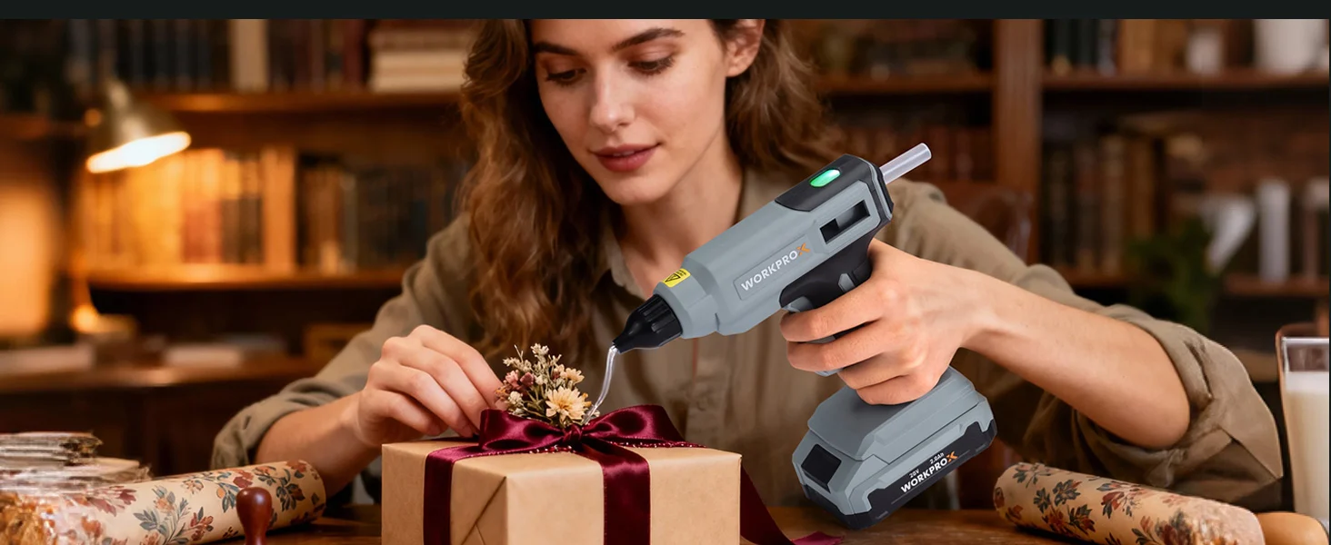Handheld device in gray with green indicator lights being used to wrap a gift box with ribbon on a table