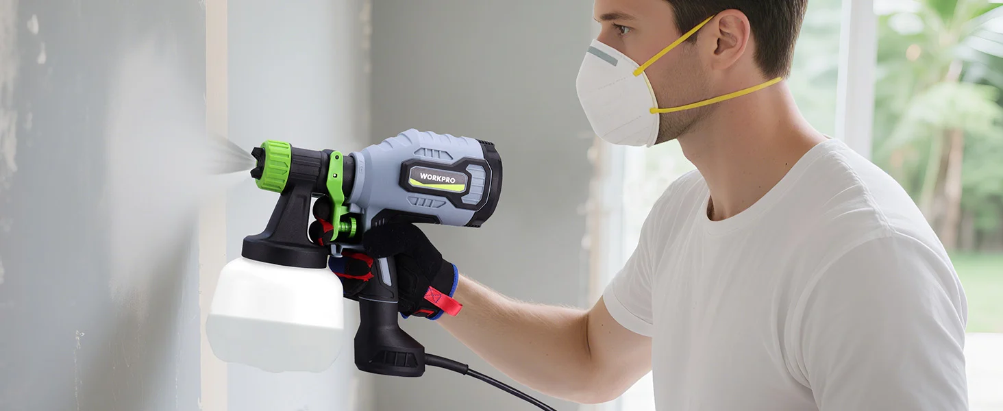 Worker wearing a mask uses a cordless sprayer with green and black parts, showing innovation and quality