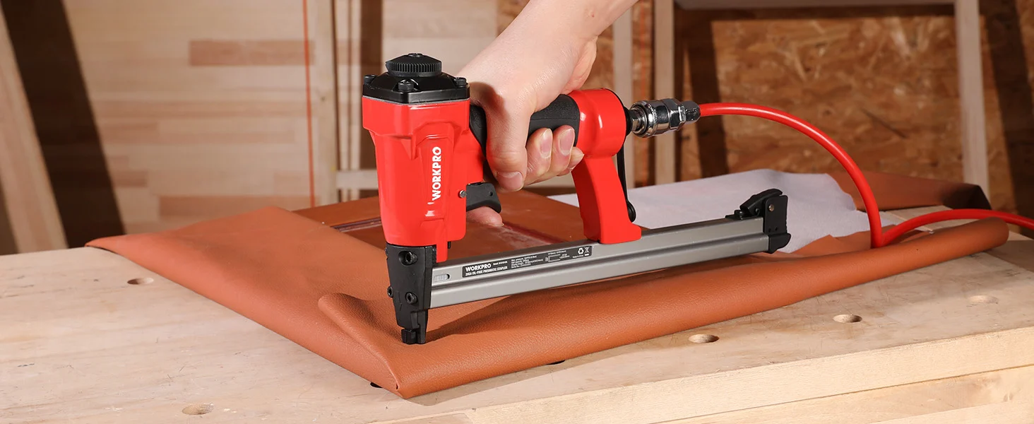 Hand using a red stapler to fasten brown leather on a wooden board, showing innovation and quality