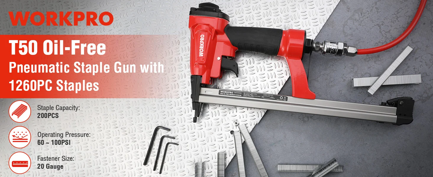 Pneumatic staple gun with red and black handle on a textured metal surface, with staples and hose