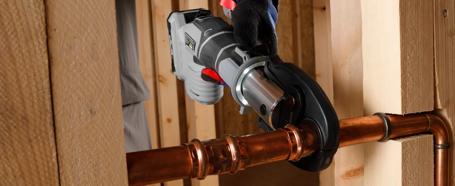 Angle grinder cutting copper pipe in a wooden workshop, showing innovation and durable quality with secure grip