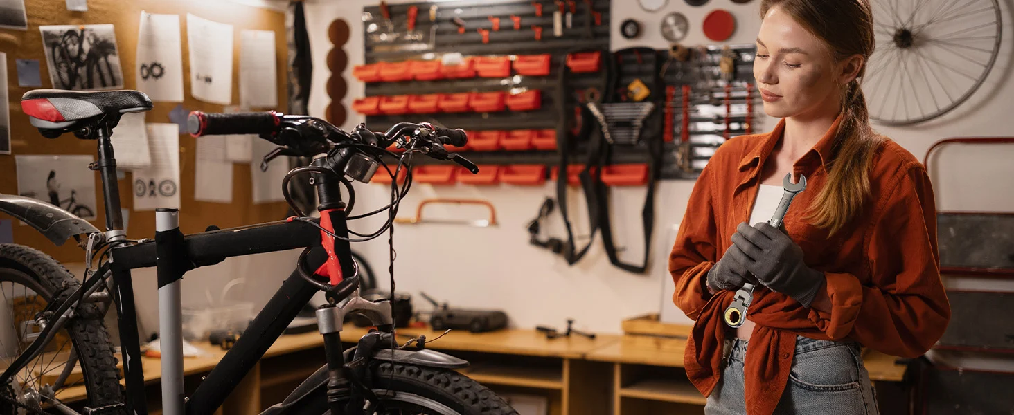 Mechanic in a workshop adjusts a bicycle handlebar, with innovation and quality shown in the tools and bike frame