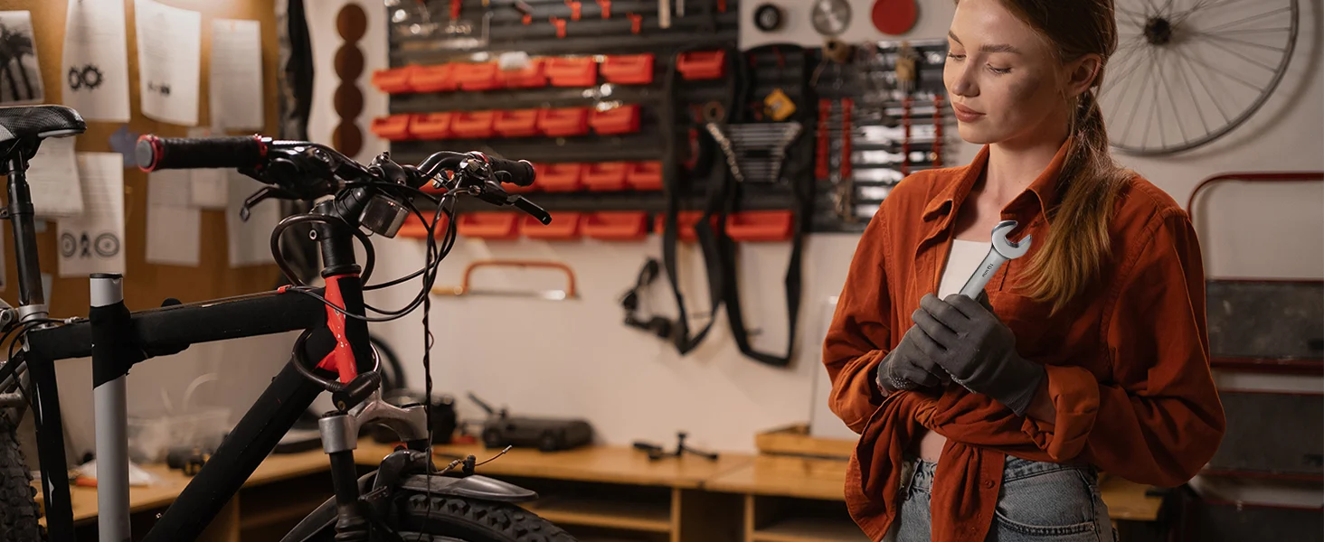 Woman in a workshop tightening a bicycle part with a wrench, with innovation and quality in the tools